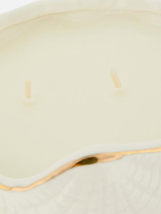 Candle in ceramic seashell container