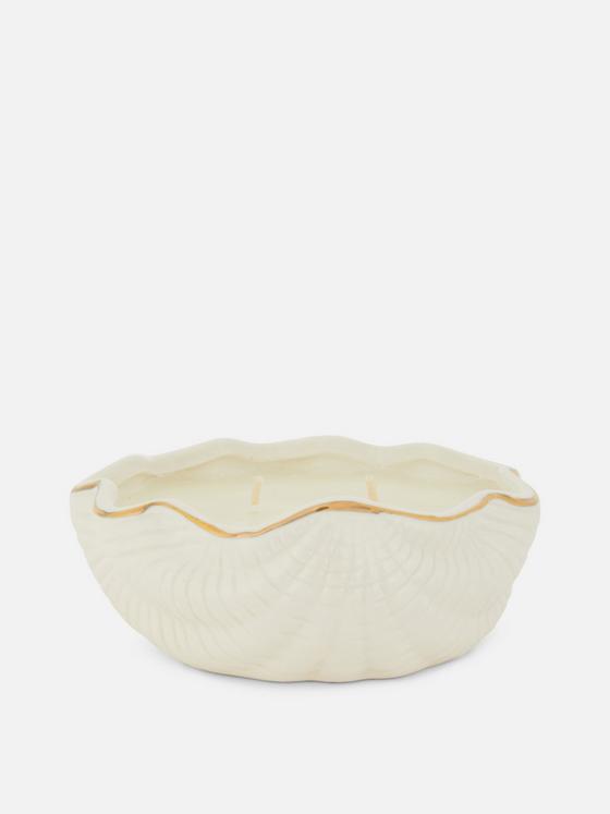 Candle in ceramic seashell container