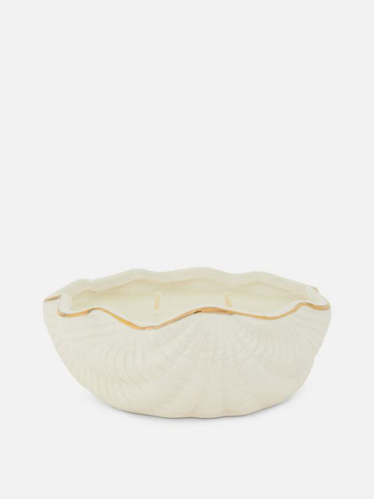 Candle in ceramic seashell container
